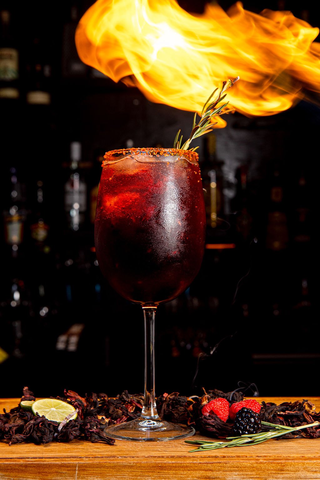 REDSPOT cocktail photograph: a red drink in a wine glass under a burst of flame